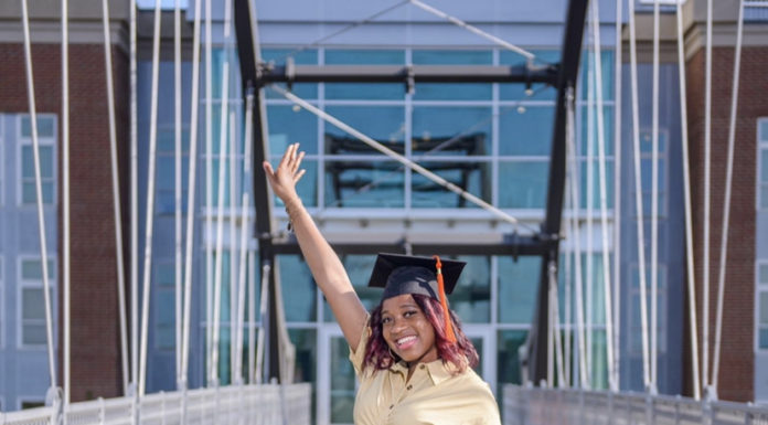Graduate Spotlight: Mikayla Alves A young woman wearing a graduation cap poses on a bridge