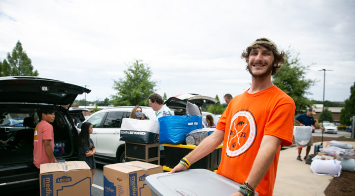 4 things to know about Mercer’s 2022 Opening Days and Bear Beginnings A young man wearing an orange shirt carries a large gray container. Cars and boxes are in the background
