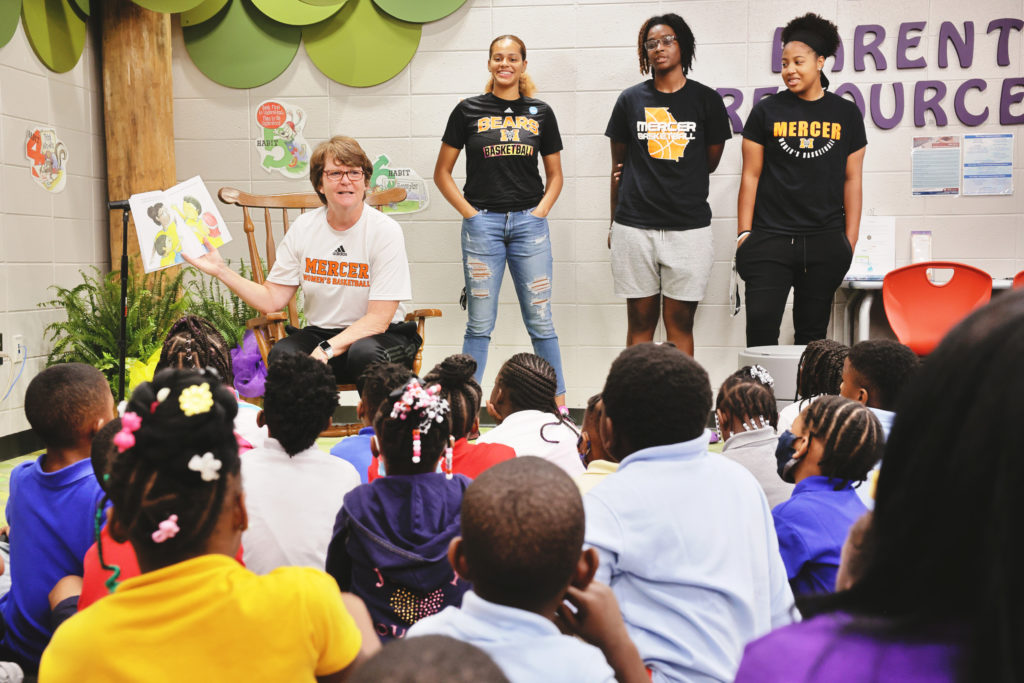 With Mercer women's basketball players by her side, Coach Susie Gardner reads her book to Hartley Elementary students on Aug. 12.
