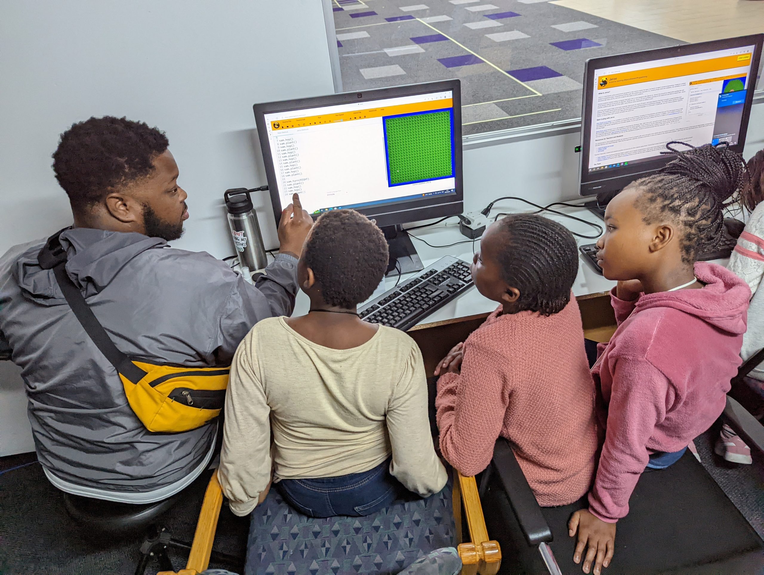Un étudiant de Mercer enseigne à des enfants du Cap une leçon d'informatique.