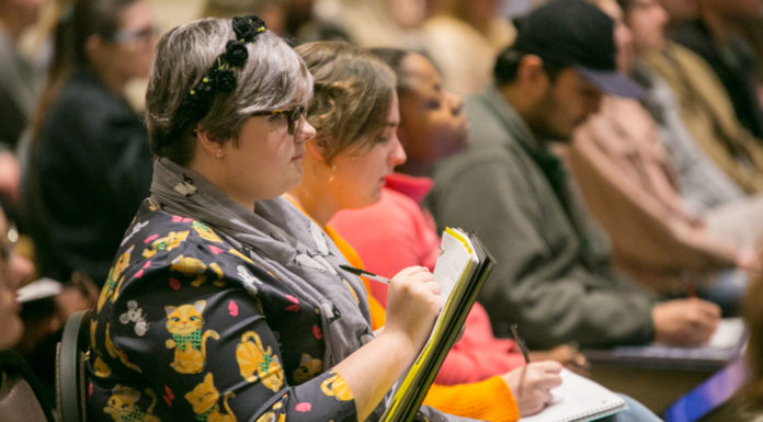Lamar Lectures to explore 19th century African American histories Profile of woman sitting in audience writing in a notebook and other audience members