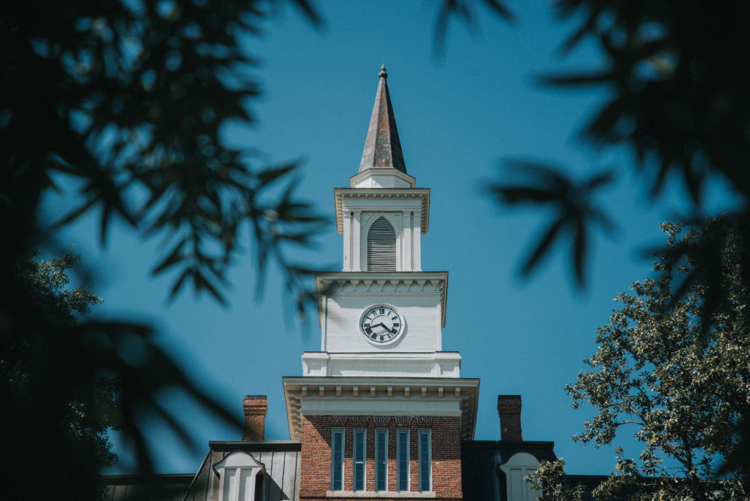 A white clock tower with a steeple atop Willingham Hall.