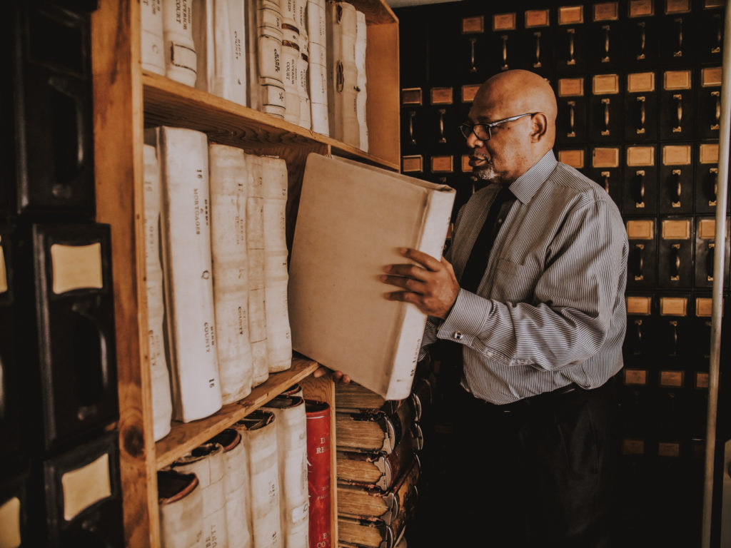 Dr. Chester Fontenot Jr., director of Mercer’s Africana studies program and Baptist Professor of English, pulls a deed book from the mezzanine area of the records vault at the Superior Court Clerk’s Office. 