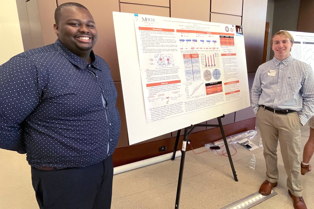 Two students give a poster presentation