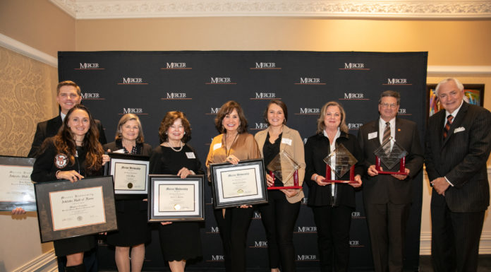 7th annual Alumni Awards Dinner recognizes outstanding Mercerians people stand holding awards in front of a mercer backdrop