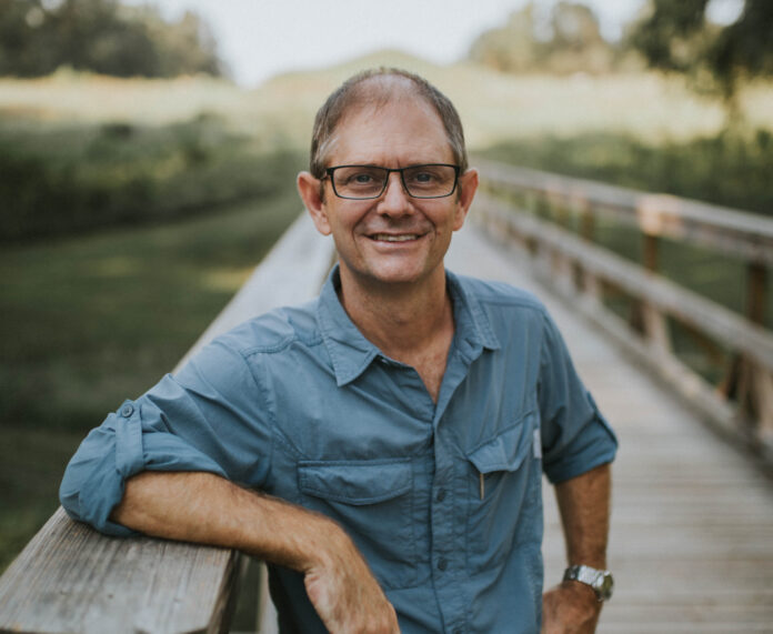 Gordon Johnston stands on a boardwalk.