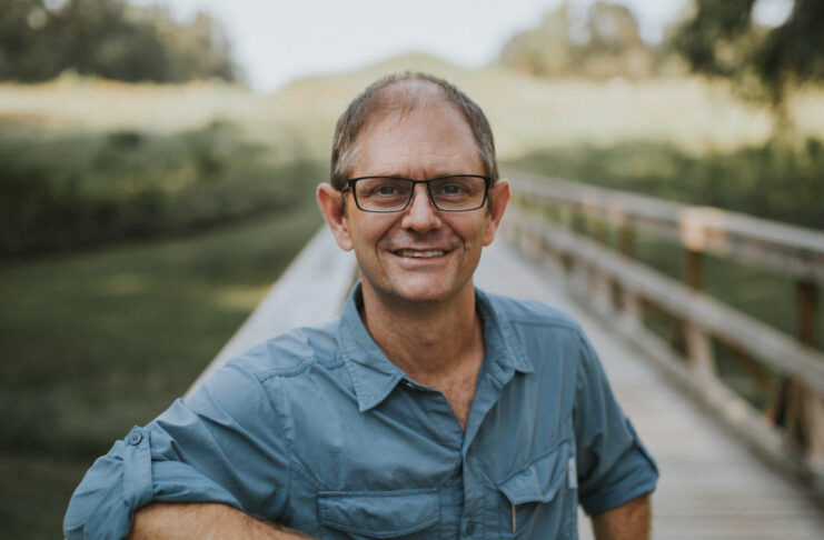 Gordon Johnston stands on a boardwalk.