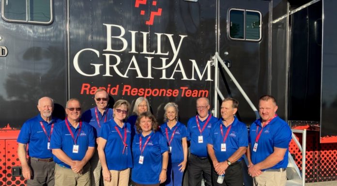 Professor serves as lay chaplain helping with Hurricane Ian relief efforts Ten people wearing blue shirts and khaki pants stand in front of a large vehicle that says "Bill Graham Rapid Response Team"