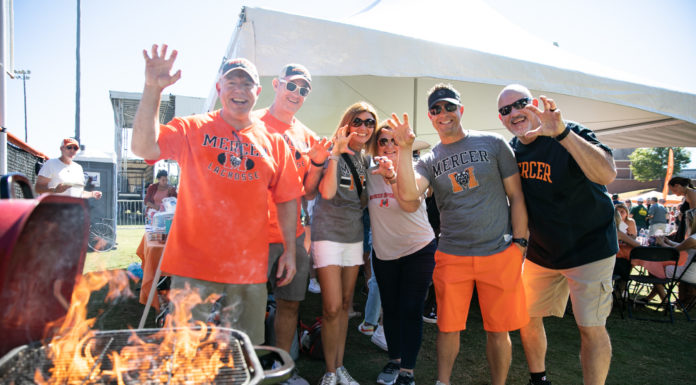 3 things to know about Mercer vs. Furman football game day Six people wearing Mercer shirts make their hands into the shape of a claw while standing in front of a grill with flames