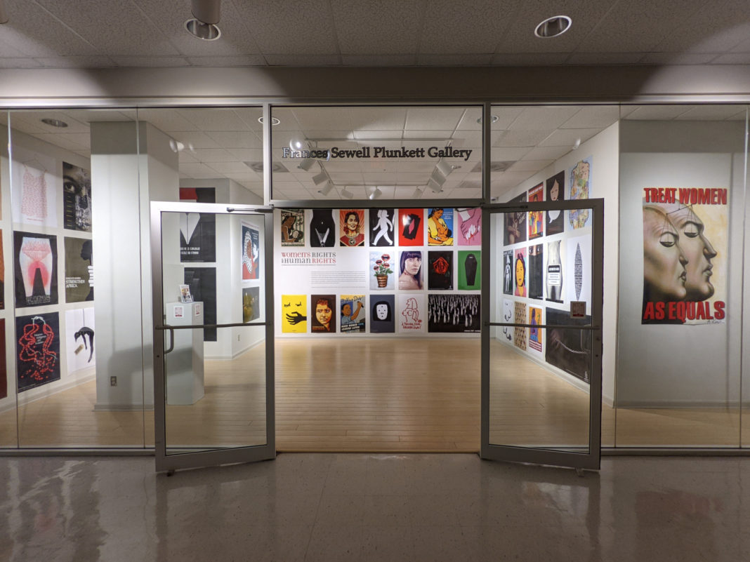 glass doors open up into an exhibit with colorful poster on the wall