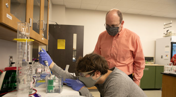 Mercer’s biochemistry and molecular biology program receives ASBMB accreditation A male professor looks on while a male student pipes a liquid into a container