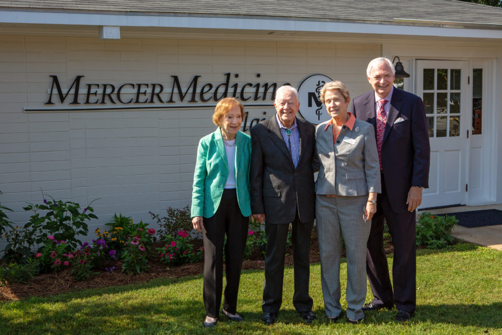 Rosalynn Carter, Jimmy Carter, Jean Sumner and William D. Underwood stand in front of the Mercer Medicine clinic in Plains, Georgia.