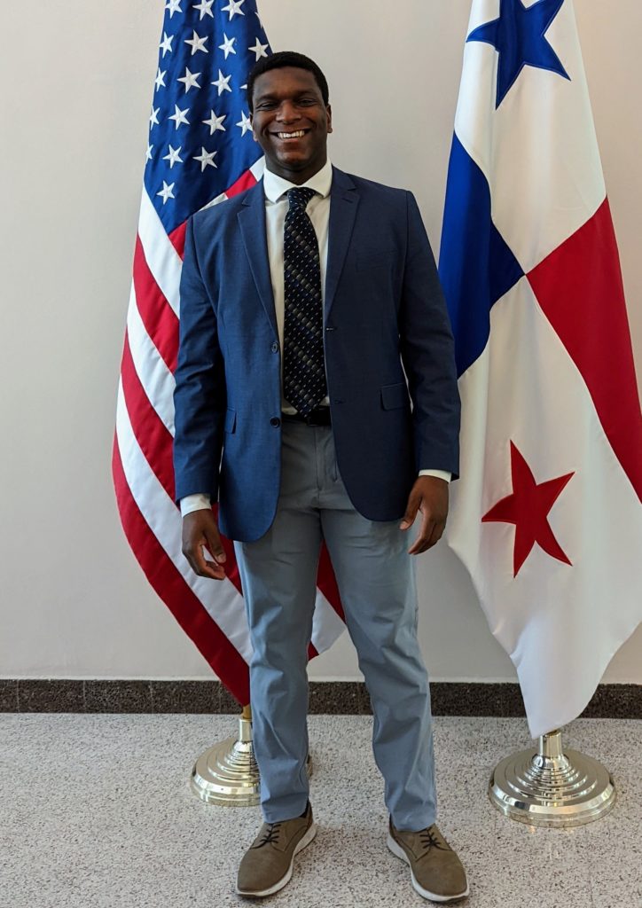 Donald Williams Jr. in front of U.S. and Panama flags.