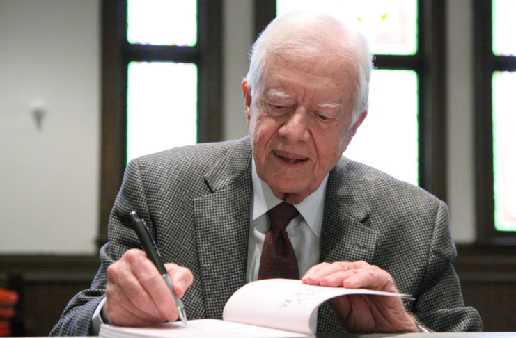 Jimmy Carter signs a book.