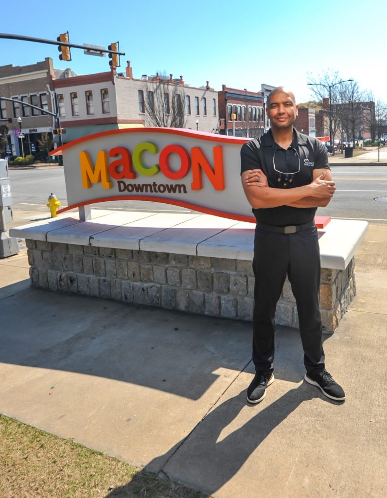 Dr. Samer Othman is shown in front of the Downtown Macon sign.