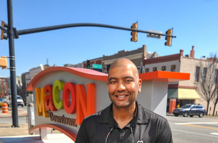 Dr. Samer Othman is shown in from of the Macon sign in downtown Macon.