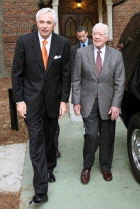 William D. Underwood and Jimmy Carter walk on a sidewalk.