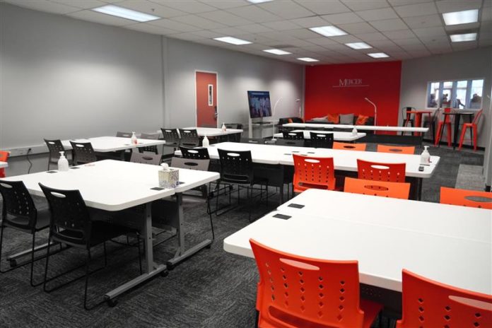 Tables and chairs are seen inside the Workforce Innovation Lab.