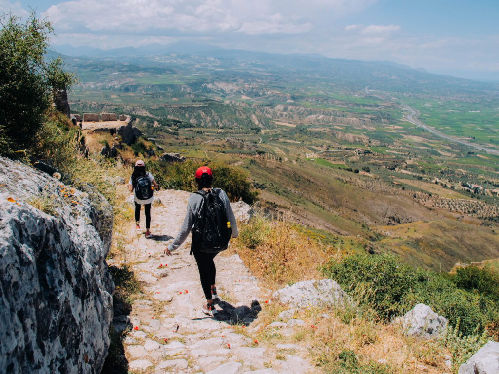 students walk along a mountain path in greece