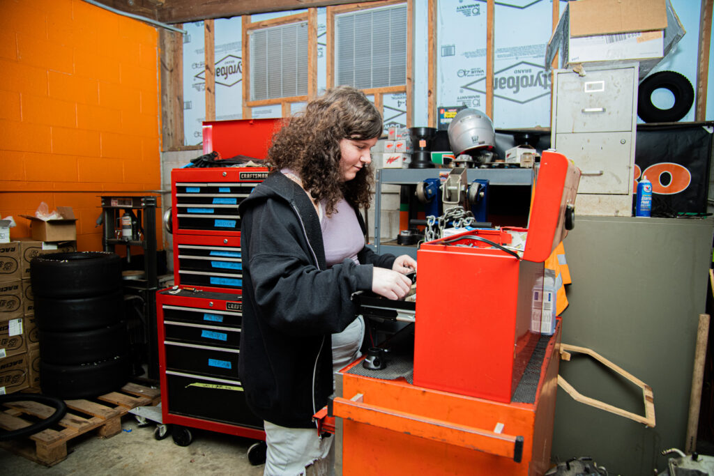 A student looks inside a tool chest inside the garage.