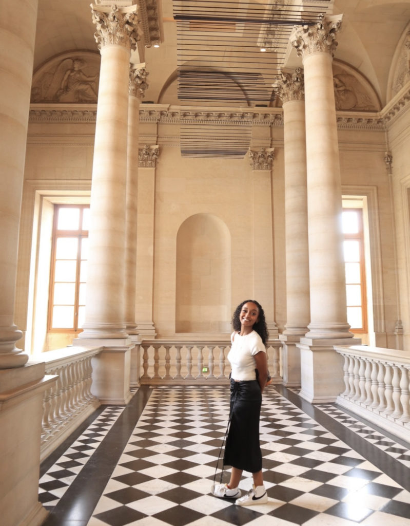 Abigail Yemisrach stands in front of two big columns