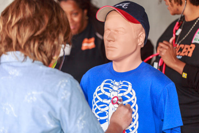 a participants places a stethoscope on a dummy's chest
