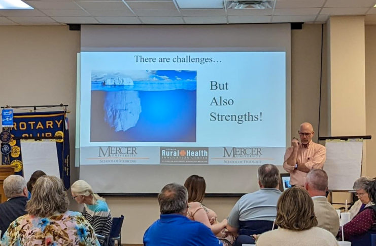 people look at a projected image of an iceberg. words say there are challenges ... but also strengths