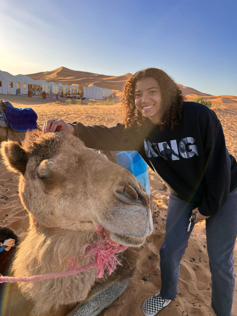 Nyiah Kelley next to a camel in the desert