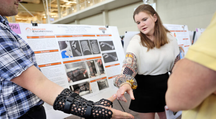 13th annual BEAR Day to showcase research, special projects in Macon a student wears a brace on his wrist and another student points at it