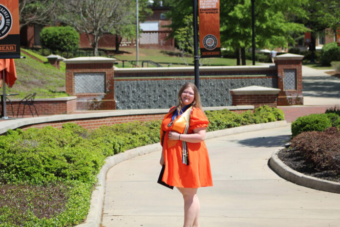 abigail durant wears an orange dress on the macon campus