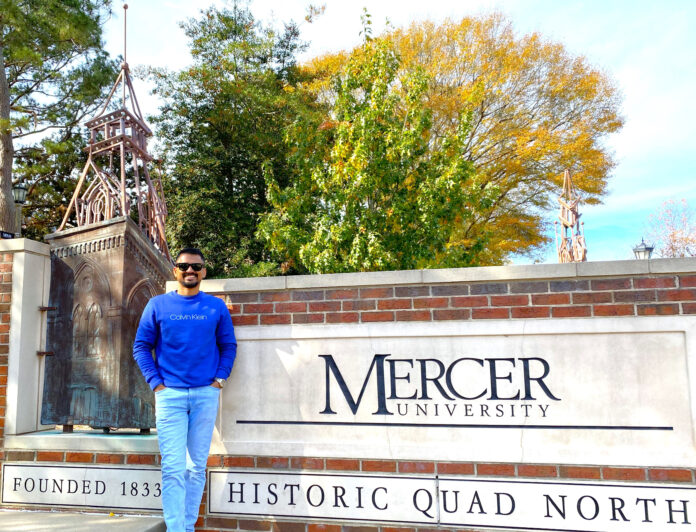 Ahasanul Hasan stands in front of a Mercer sign
