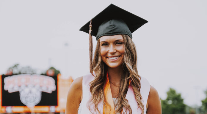 Graduate Spotlight: Bella Doane bella doane stands on the football field while wearing a graduation cap