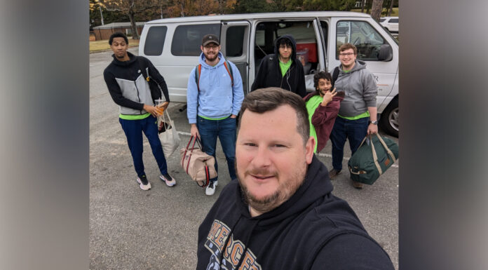 Cybersecurity team shows hacking skills as part of offensive security competition A selfie of five people in front of a van.