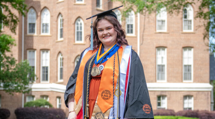 Graduate Spotlight: Lara Edgeman lara edgeman wears graduation gear in front of the administration building