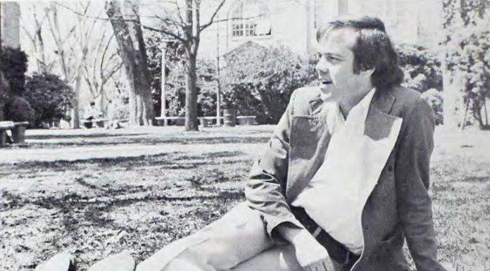 Dr. Michael Cass known for his wisdom, wit and mentorship | Mercer Legends Dr. Mike Cass sitting in the grass on campus with a book.