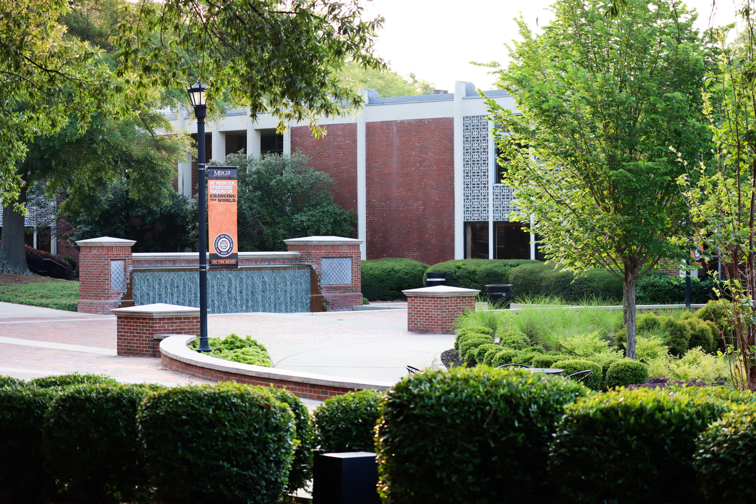 A view of the Macon campus, showing shrubs and a waterfall in front of Connell Student Center.