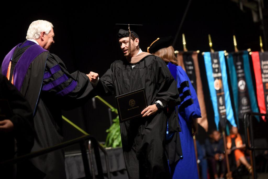 graduate shakes hand of mercer president