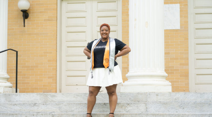 Graduate Spotlight: Teara Johnson Woman stands triumphantly on steps