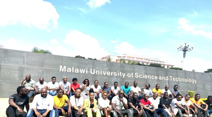 Professor conducts ecological field research, STEM work in Malawi A group of people is shown in front of a sign for Malawi University of Science and Technology.