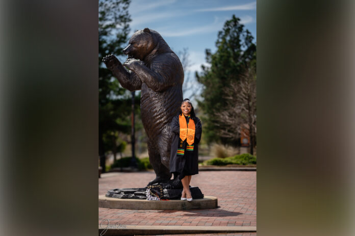 krysten wright in front of bear statue