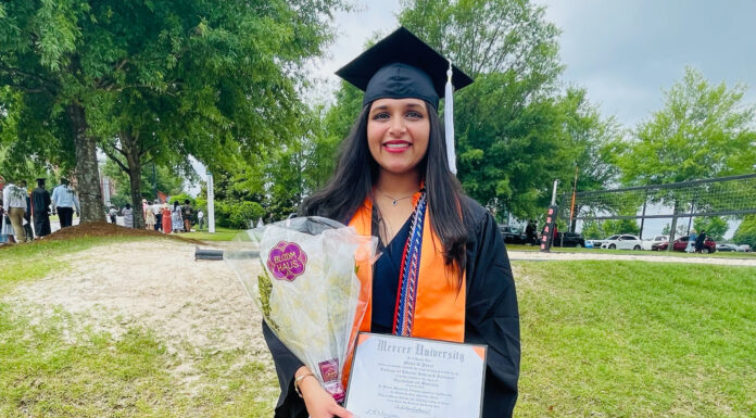 Graduate Spotlight: Mahi Patel Mahi Patel, wearing graduation cap and gown, holds flowers and her diploma