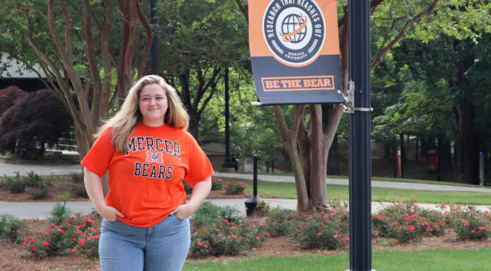 Graduate Spotlight: Samantha Cannon samantha cannon stands next to a banner on mercer's campus.