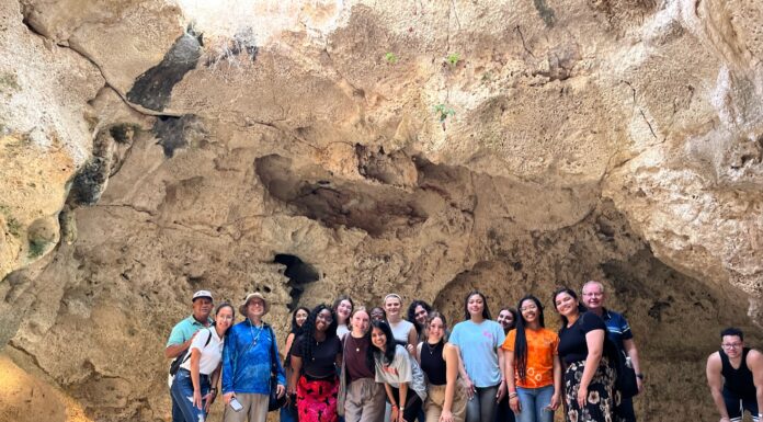 Service Scholars teach English language lessons in Dominican Republic A group of students stands together in a cave.