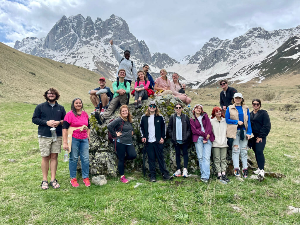 a group photo in front of snow capped mountains