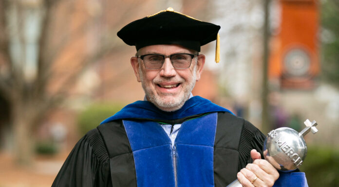 Dr. John Thomas (Tom) Scott appointed interim dean of College of Liberal Arts and Sciences man in faculty graduation regalia holding a mace
