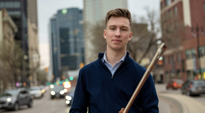 McDuffie Center student recognized as rising classical music star in Canada student standing in a city holds a violin