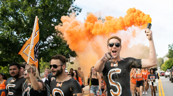 3 things to know about Mercer vs. Morehead State football game day students with painted black chests wave a mercer flag and orange smoke