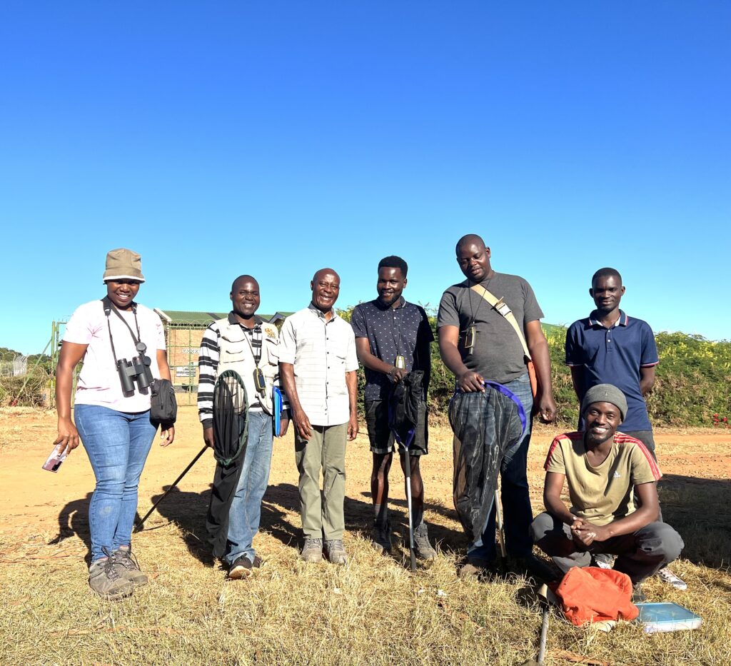 7 adults posing in Southeast African field