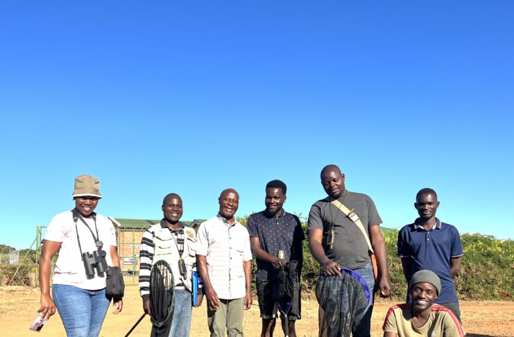 7 adults posing in Southeast African field