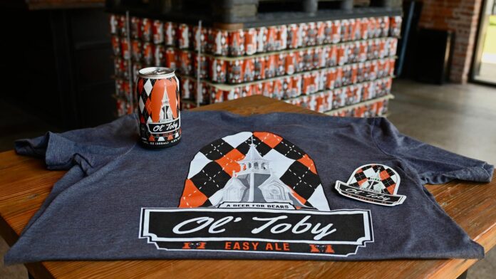 ol' toby easy ale beer can sits on a branded ol' toby easy ale T-shirt
